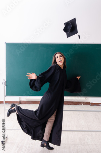 Female graduate student in front of green board 