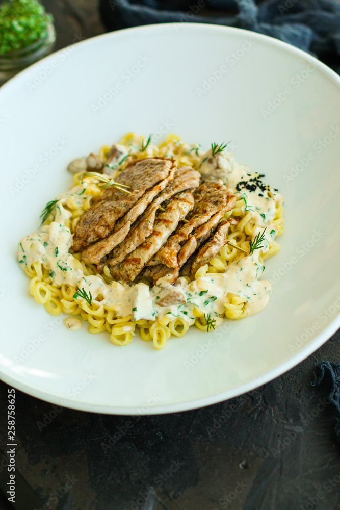 roast meat, pasta fine Annellini and creamy sauce (main dish). food background. top view roast meat, pasta fine Annellini and creamy sauce (main dish). food background. top view