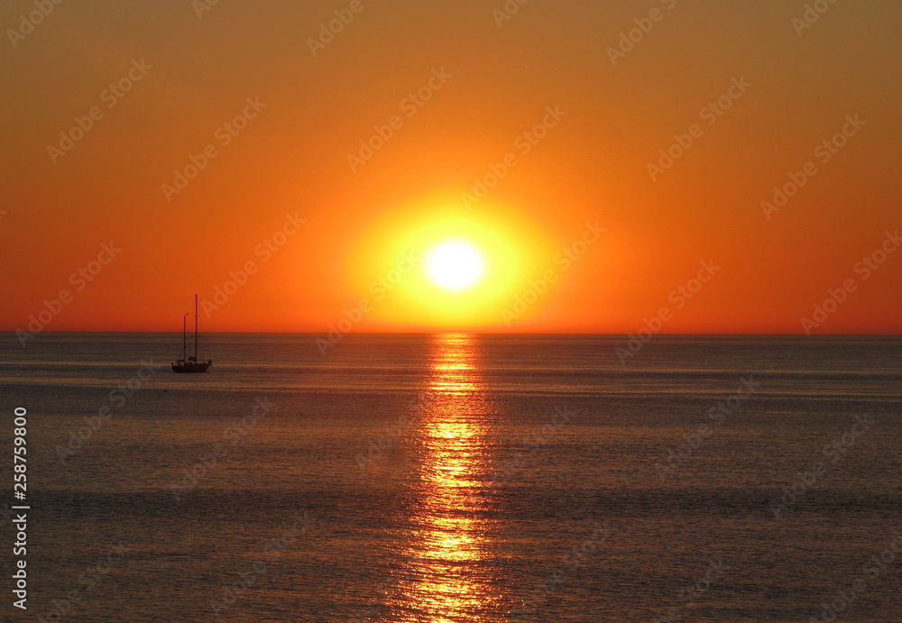 Ship on the background of the sunset on the sea.
