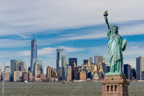 The Statue of Liberty with One World Trade Center and Manhattan downtown financial district in background, Landmarks of New York City, New York skyscrapers at Lower Manhattan, New York City, USA.