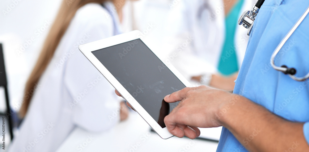 Surgeon doctor using tablet computer, close-up of hands at touch pad screen Surgeon doctor using tablet computer, close-up of hands at touch pad screen