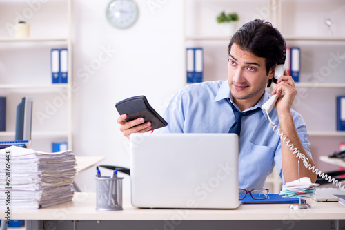 Young male businessman employee unhappy with excessive work  