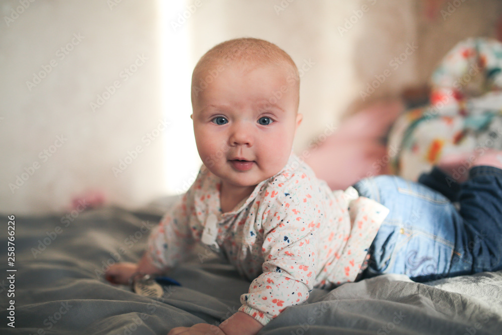 Funny baby lying on bed in the real interior Funny baby lying on bed in the real interior