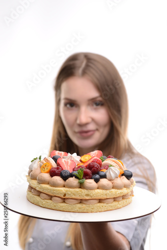 baker girl with a cake with berries on a white background