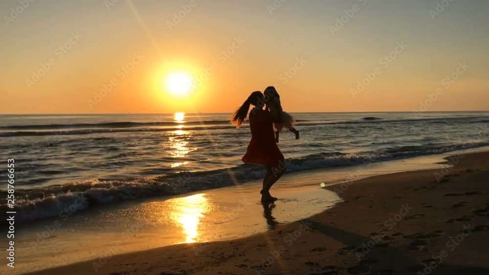 Mother and daughter spinning around at sunset. Mother and daughter spinning around at sunset.