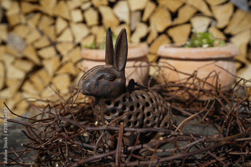 Fototapeta premium Happy Easter - Osterhase Hase mit Holz im Hintergrund
