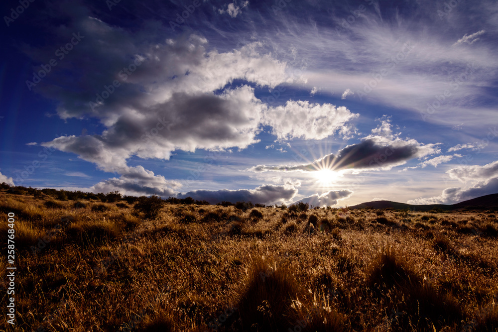 Countryside view against blue sky and sun Countryside view against blue sky and sun
