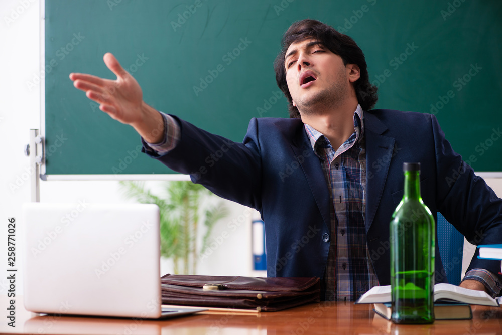 Male teacher drinking in the classroom Male teacher drinking in the classroom