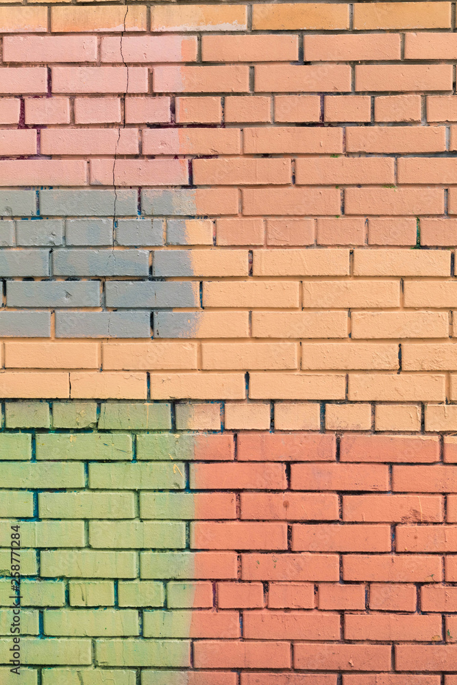 Fototapeta premium Brick wall from a new brick. The wall is painted with multi-colored paint of pastel tones