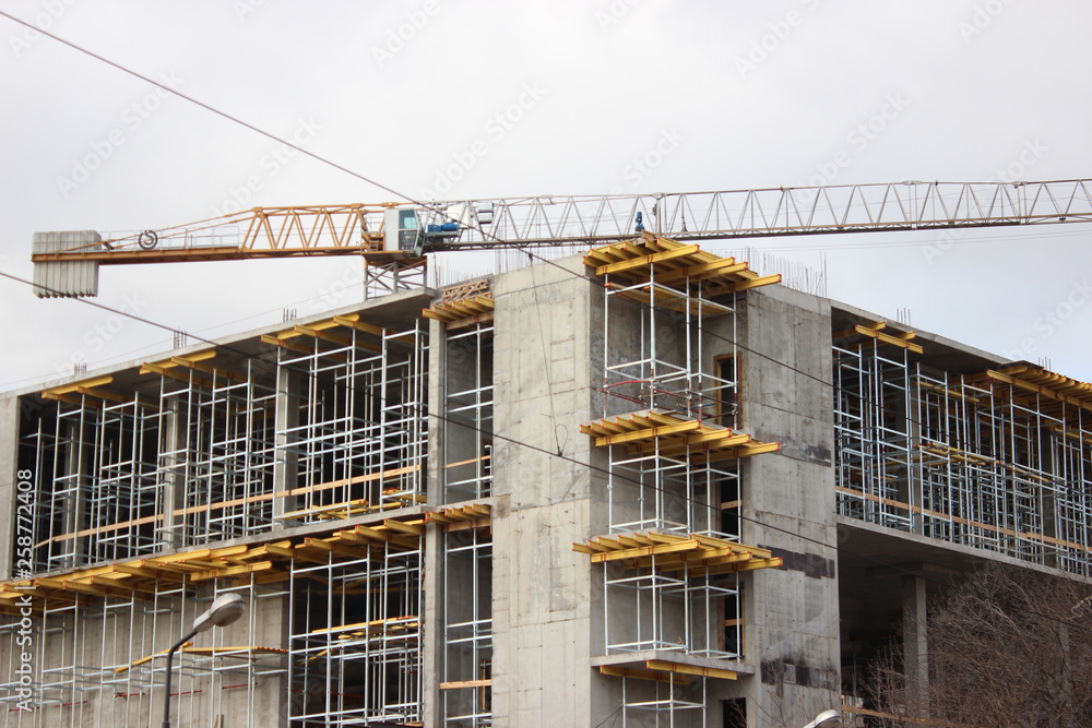 the destruction of the old building, reconstruction, structural changes. construction, high-rise crane works on the site. the building is made of brick, tiles on the walls. installation,