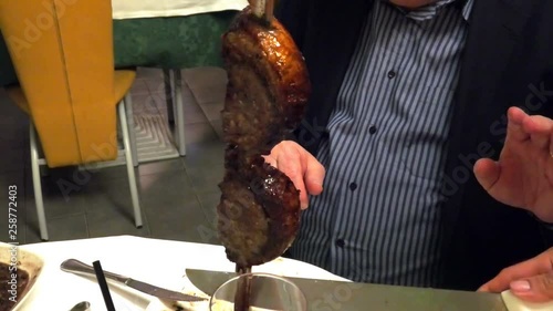 Close up of a picanha roast beef cut on the sword in Brazilian churrasqueira: typical Brazilian restaurant with grill. photo