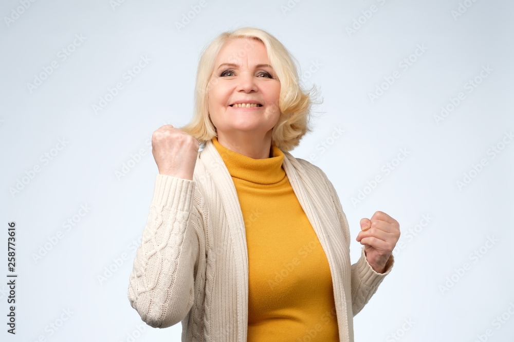 Happy senior woman winner clenching her fists. Happy senior woman winner clenching her fists.