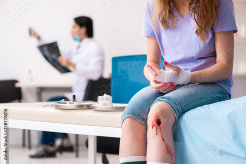 Leg injured young woman visiting male doctor 