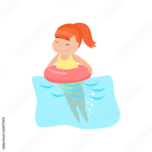Happy smiling girl swimming in inflatable rubber swimming ring in pool in aquapark