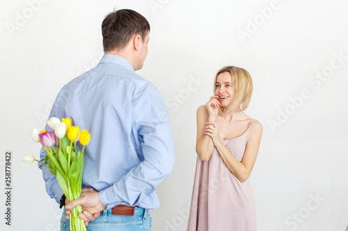 Man gives a bouquet of flowers to woman