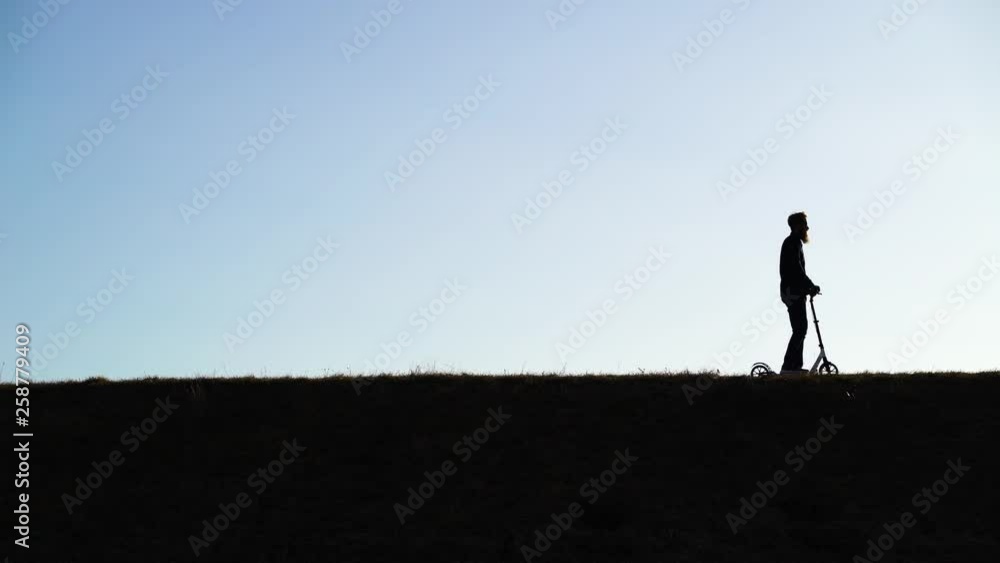 Shadow image of man riding kick scooter at public park, Zagreb, Croatia. Shadow image of man riding kick scooter at public park, Zagreb, Croatia.