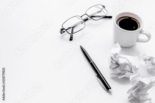 blogger office desk with glasses, coffee and paper balls on white background copyspace