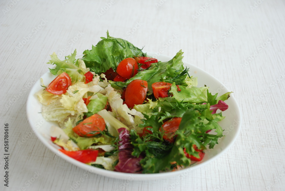 Vegetable salad for a healthy lunch consists of Petsay, Frize, Radicchio leaves. The salad has cherry tomatoes, red pepper, dill, olive oil. Vegetable salad for a healthy lunch consists of Petsay, Frize, Radicchio leaves. The salad has cherry tomatoes, red pepper, dill, olive oil.