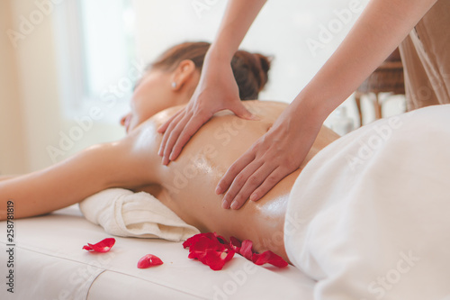 Beautiful woman lying down on the bed relax in spa salon with massage.