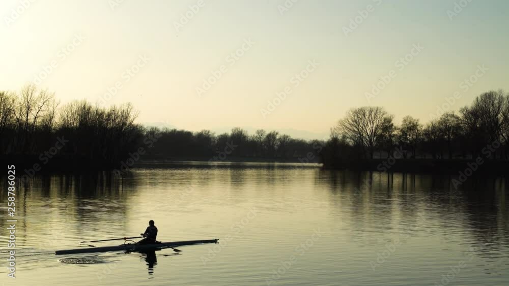 Image of man rowing alone at an artificial lake during sunset, Zagreb, Croatia. Image of man rowing alone at an artificial lake during sunset, Zagreb, Croatia.