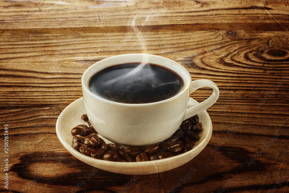 Hot coffee with hot steam and coffee beans on wooden table