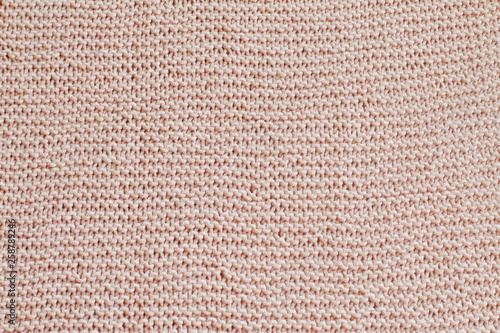 Seamy hand-knitted fabric from delicate pink threads. Knitted background.