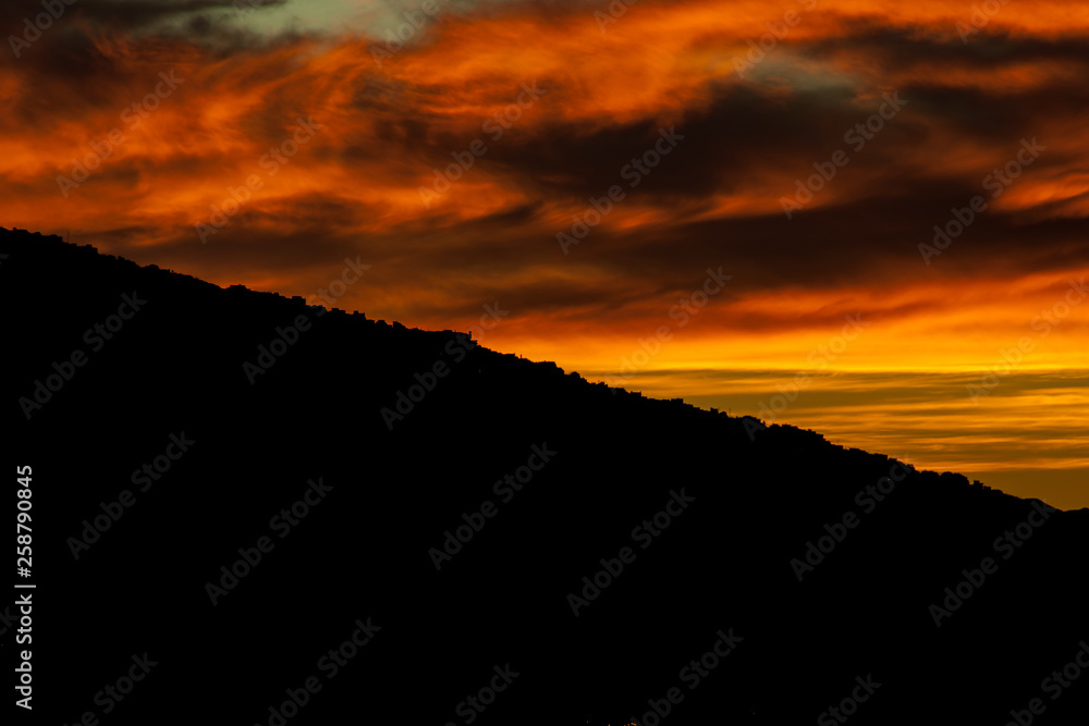 sensational sunset behind the mountain with cloud formations