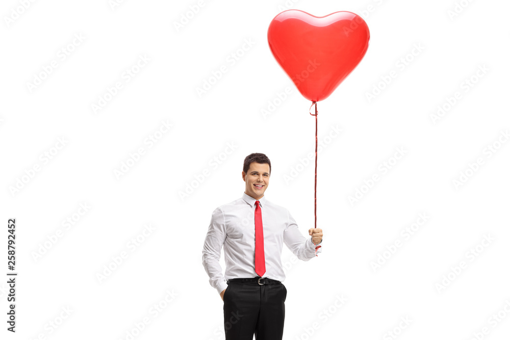 Young man holding a heart shaped balloon Young man holding a heart shaped balloon