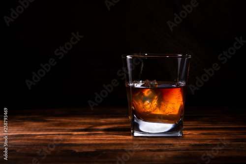 glass of whiskey or cognac on a wooden background © Владимир Солдатов