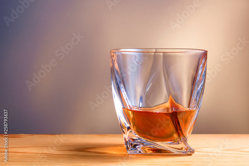 glass of whiskey or cognac on a wooden table