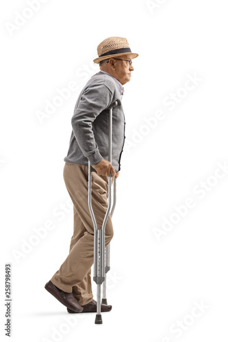 Elderly man walking with crutches