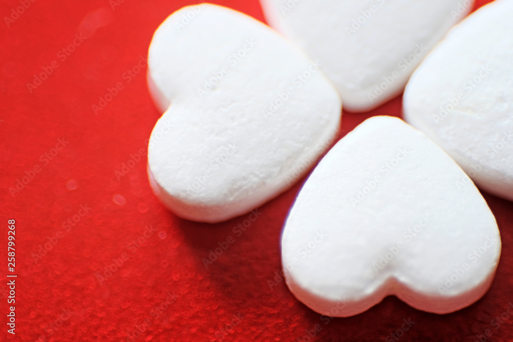 Heart-shaped pills on a red background. Red felt background. Heart disease medications. Close up. Heart-shaped pills on a red background. Red felt background. Heart disease medications. Close up.