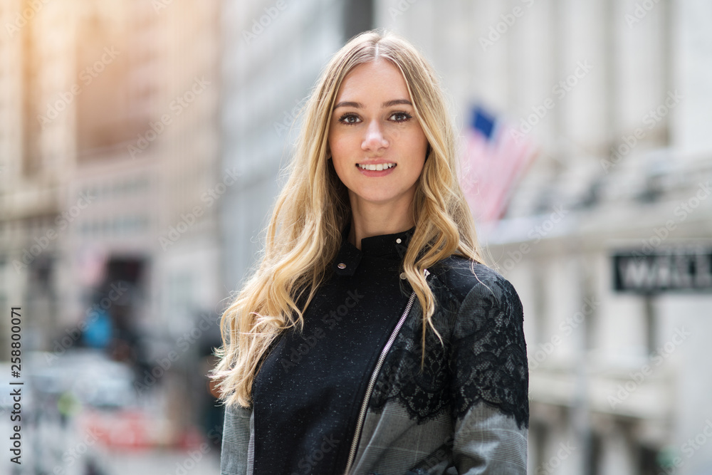 Beautiful young adult smiling businesswoman portrait in New York City Wall Street