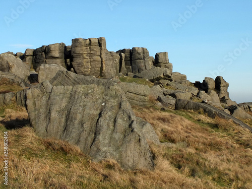 large rugged gritstone outcrop at the bridestones a large rock formation in west yorkshire near todmordenwith blue sky and surrounding countryside © Philip J Openshaw 