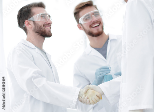 blurred image of a handshake between scientists