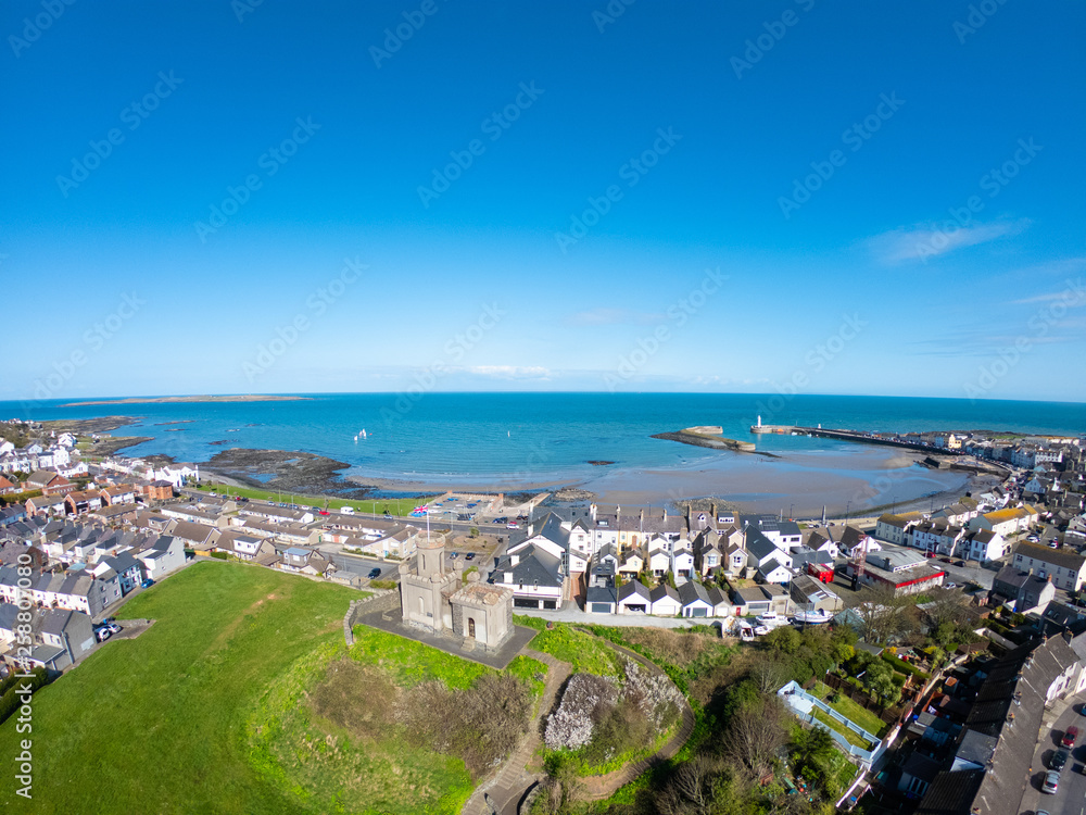 aerial view of buildings, houses on Coast of Irish Sea against clear blue sky. Castle on hill in Donaghadee, Northern Ireland