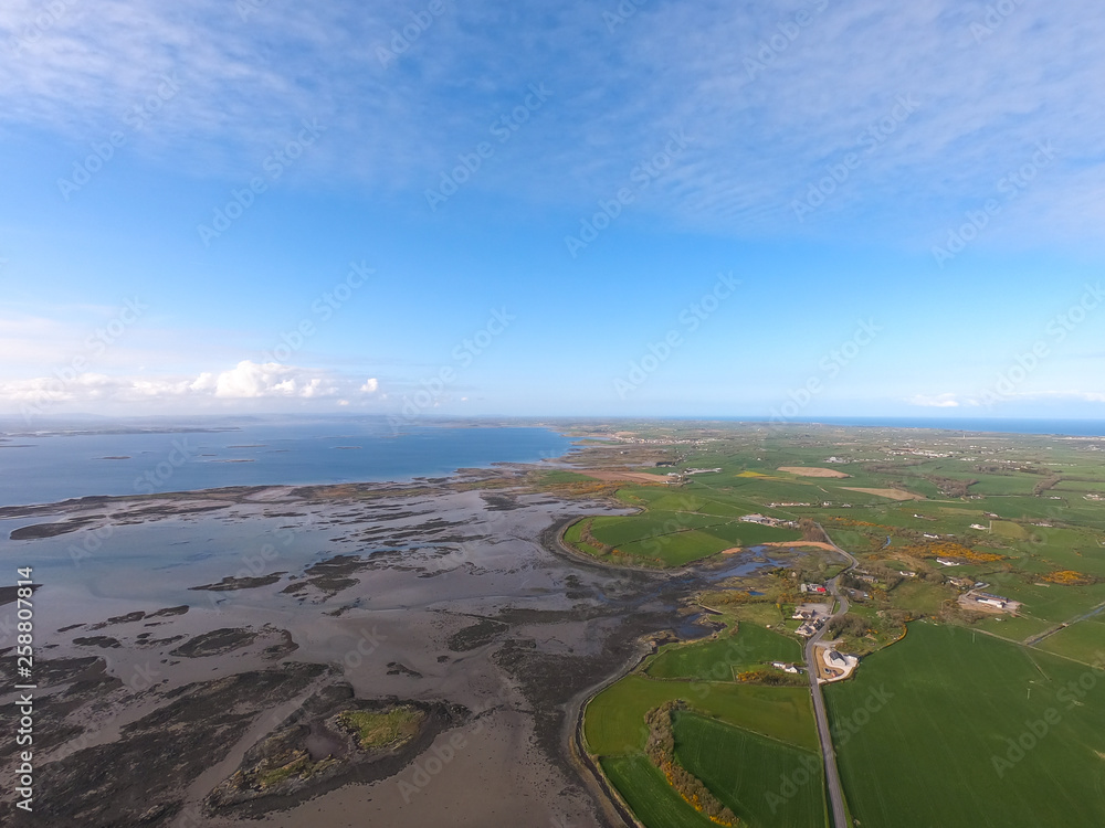 Aerial view of green fields and coast of Irish Sea in Northern Ireland. Coastal Route Aerial view of green fields and coast of Irish Sea in Northern Ireland. Coastal Route