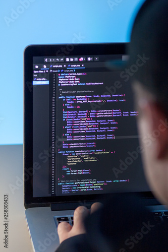 Programmer working on laptop computer in office