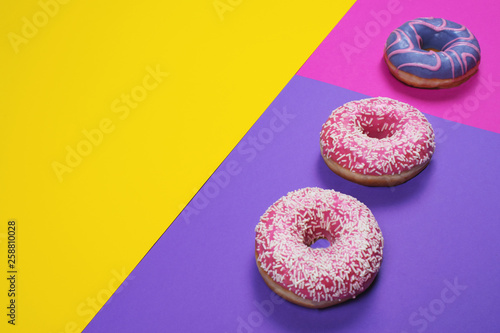 Three colorful donuts on multi colored background