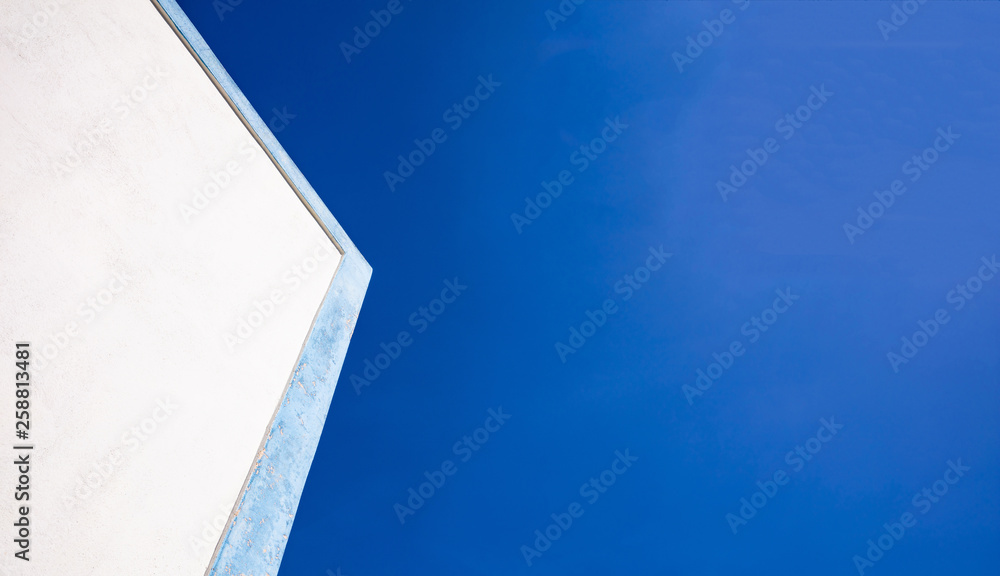 Greece. White building with blue details closeup view, blue sky background, copy space Greece. White building with blue details closeup view, blue sky background, copy space