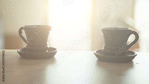 Slow motion footage of Waiter bringing a fresh maiden coffee in black clay cup and putting on table close up view. Coffee consummation in modern coffee shop concept cinematic 