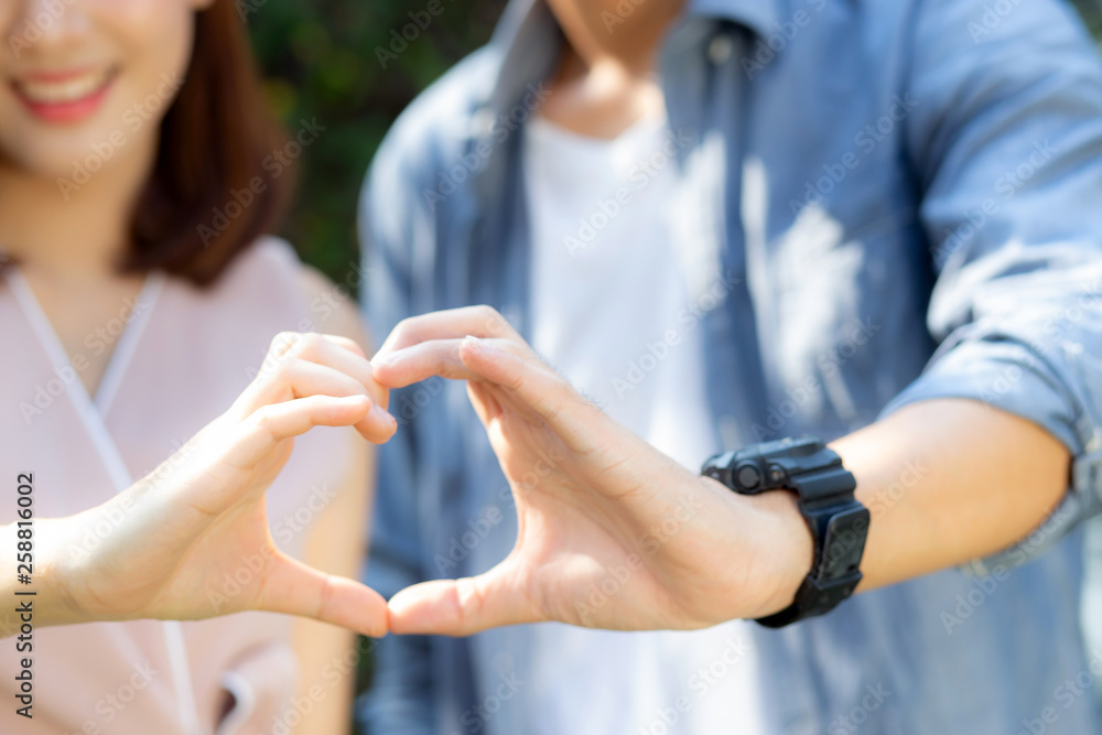 Closeup of happy couple fun making gesture heart shape with hand outdoor together, man and woman with relation feeling love with symbol and sign, lover and romantic concept.