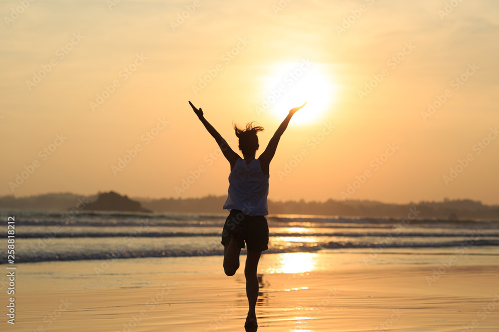 Happy Free Woman at Sunset on the Beach