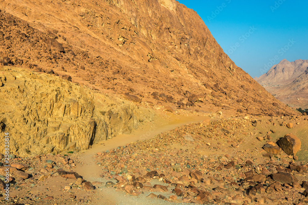 Naklejka premium Middle East or Africa, picturesque bare mountain range and a large sandy valley desert landscapes landscape photography