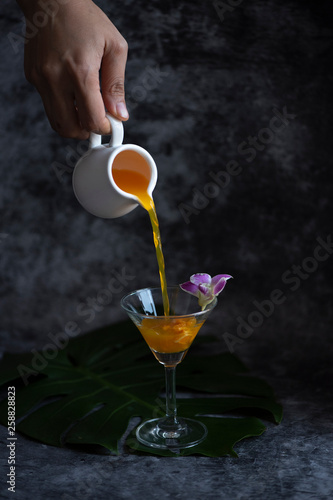 orange cocktail pouring in ...