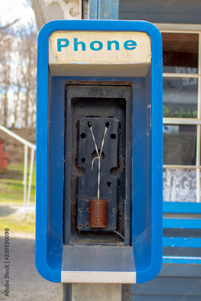 An out-of-service payphone has been equiped with older communication technology An out-of-service payphone has been equiped with older communication technology