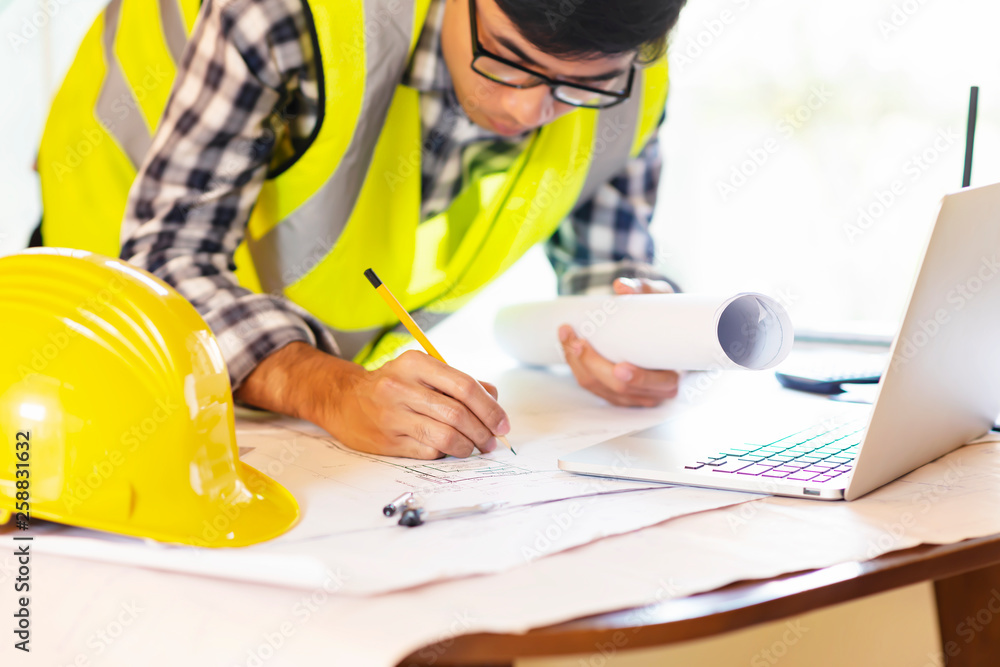 Architect working on blueprint.engineer inspective in workplace - architectural project, blueprints,ruler,calculator,laptop and divider compass. Architect working on blueprint.engineer inspective in workplace - architectural project, blueprints,ruler,calculator,laptop and divider compass.