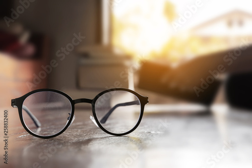 focus at glasses and background of woman sitting in a cafe, reading book.