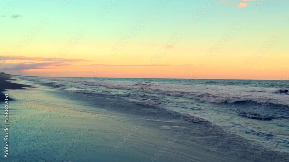 Looking out into the sunset while waves roll into a black sand beach in Monterrico on the pacific coast of Guatemala. Looking out into the sunset while waves roll into a black sand beach in Monterrico on the pacific coast of Guatemala.