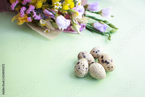 Quail eggs and a bouquet of spring flowers